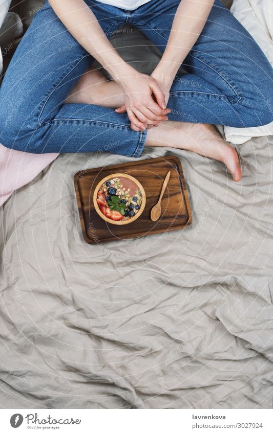 Top view of woman in jeans and white shirt in her bed Neutral Background Bamboo Bed Bedclothes Blueberry Bowl Breakfast Woman Food Healthy Eating Dish