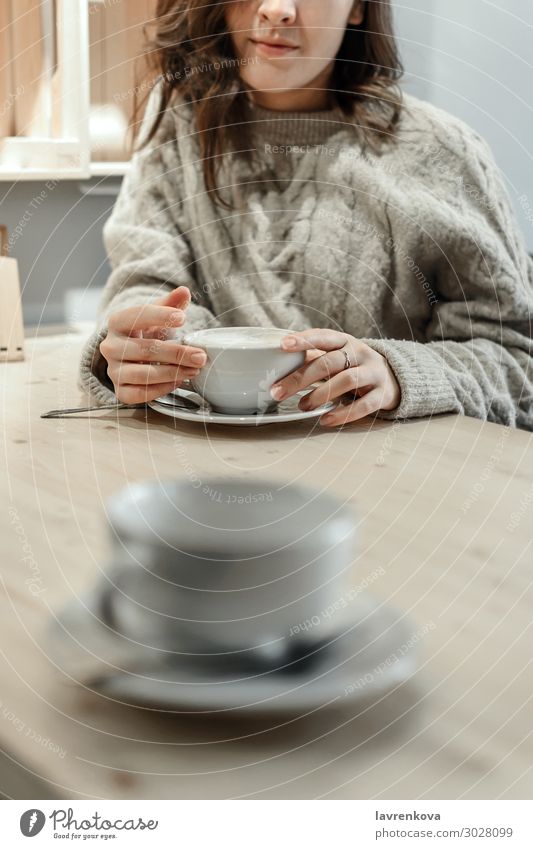 woman holding mug of latte with an empty cup in front Coffee Tea Winter Autumn Sweater Faceless Loneliness Cozy Warmth Cup Mug Date Café Table Lifestyle