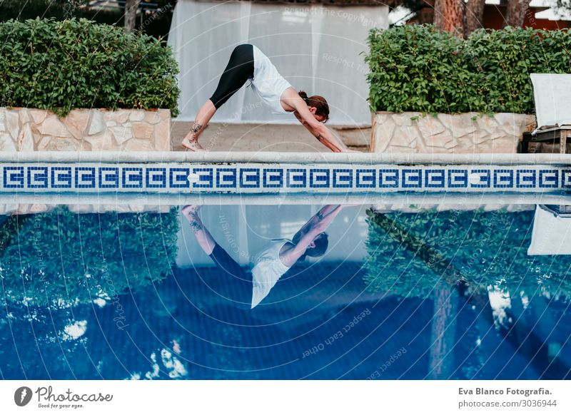 woman doing yoga by swimming pool. Yoga and mindfulness Lifestyle Beautiful Body Relaxation Calm Meditation Spa Swimming pool Leisure and hobbies