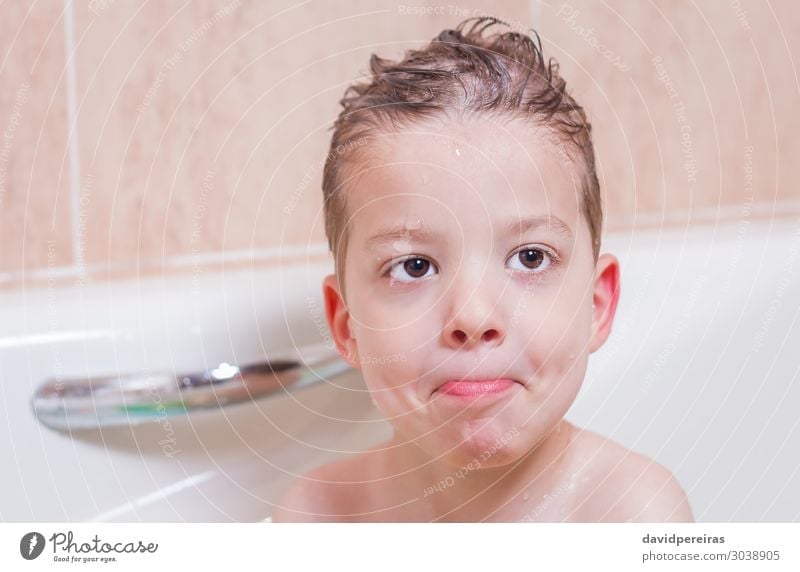 Cute Caucasian toddler enjoying bubble bath in domestic bathroom