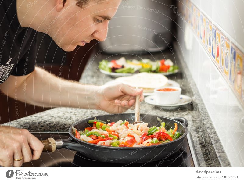Man cooking vegetables and chicken in a pan Vegetable Pan Adults Fresh Hot Green Red Tradition Chicken chili corn fajita food lettuce Mexicans Mexico nachos