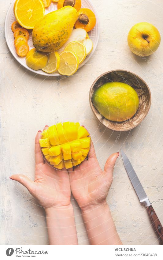 Hands holding half diced mango Food Fruit Nutrition Organic produce Vegetarian diet Diet Crockery Design Healthy Eating Table Woman Adults Yellow Mysterious