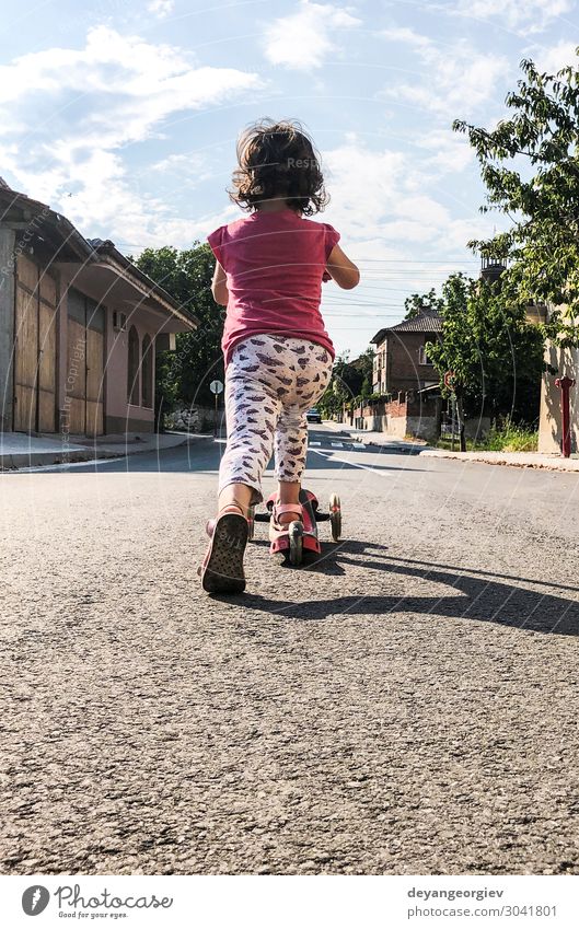 Little girl play with scooter on the street. Joy Life Leisure and hobbies Playing Sun Sports Street Movement Cute kid spring City Playful Exterior shot