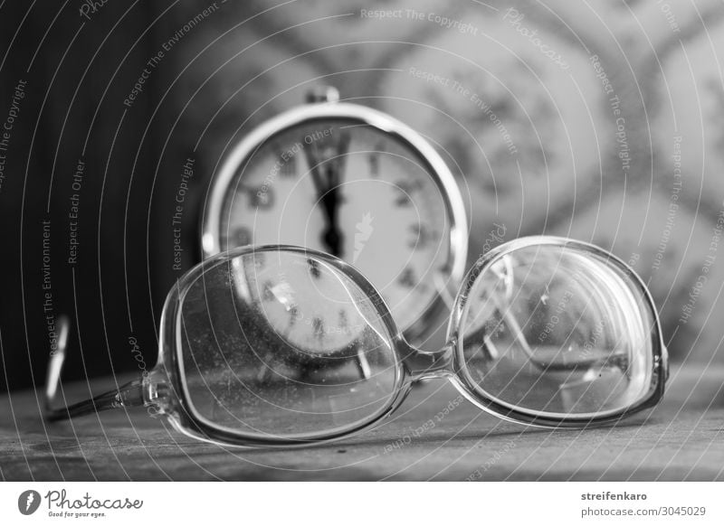 The view through the old, dirty glasses to the old alarm clock in the background showed only the more clearly that it was already five to twelve