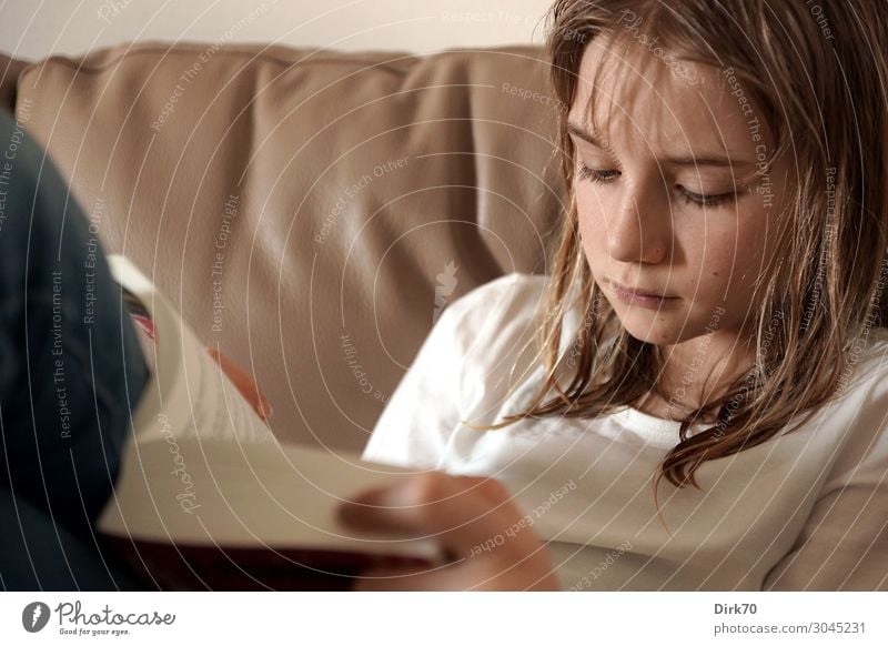 Reading educates! Young girl reading on the sofa. Leisure and hobbies Living or residing Flat (apartment) Sofa Living room Education Child Study Human being