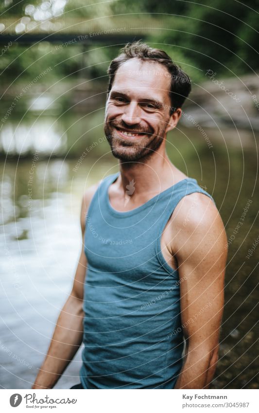 portrait of smiling man standing in the middle of a river 30s adult beard carefree casual caucasian cheerful confidence confident cool creative european freedom