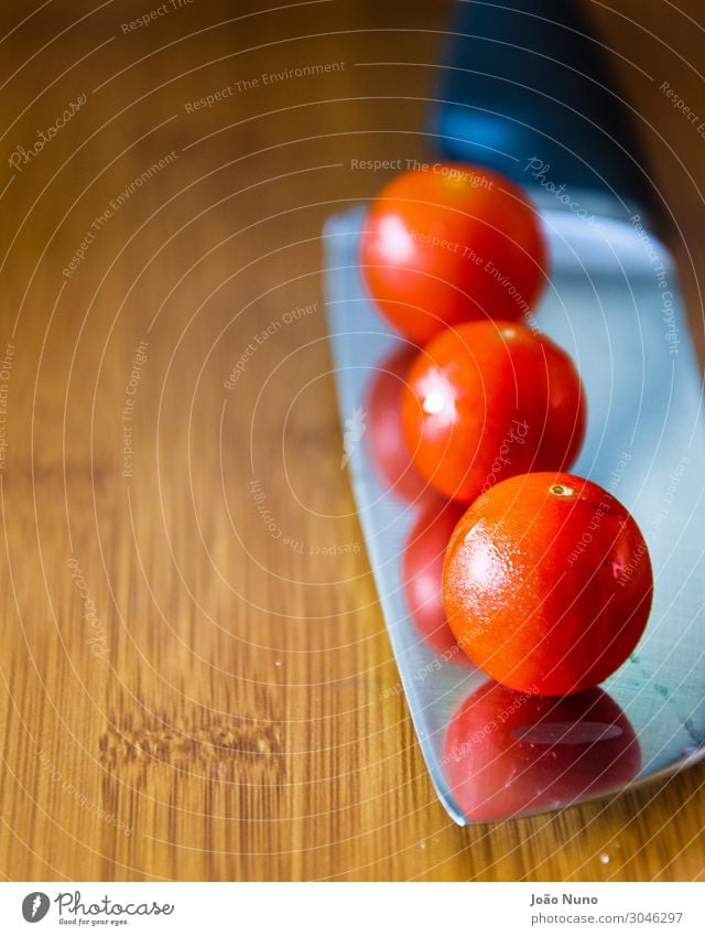 Cherry tomatoes over a chef's knife Vegetable Nutrition Lunch Organic produce Vegetarian diet Diet Cutlery Knives Metal Steel Balance Chef Chef knife