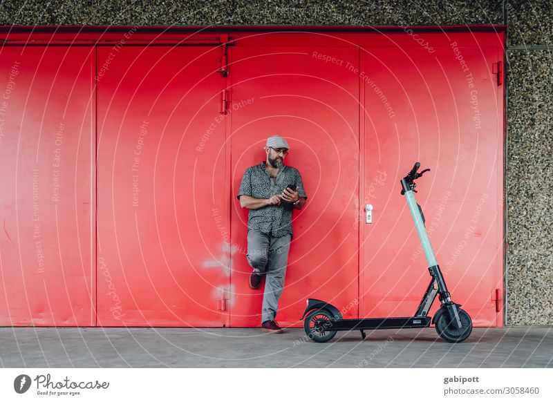Electric mobility. Man with e-scooter looks at his smartphone Lifestyle Fitness Human being Masculine Adults 1 45 - 60 years Climate Climate change Transport
