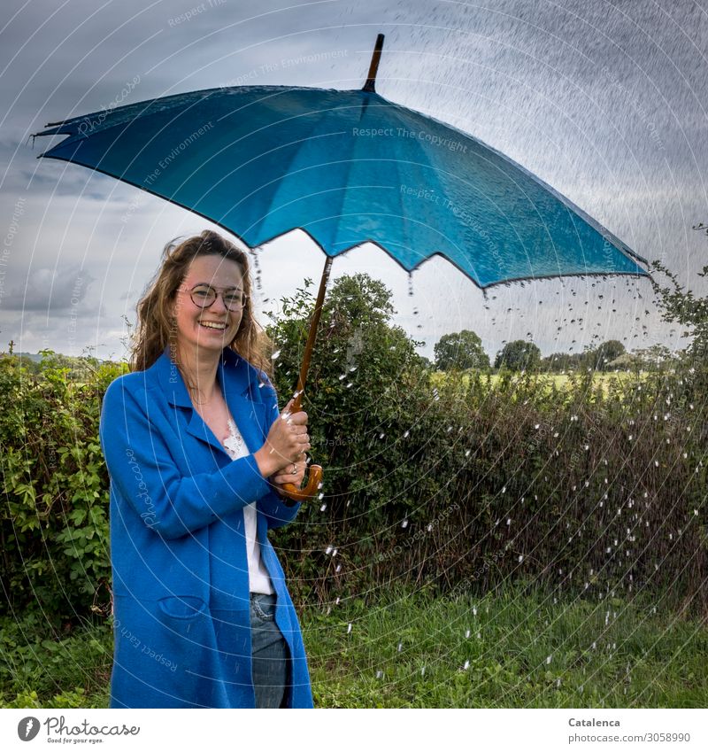 Rainy weather, water drops bounce off umbrella of young woman in blue raincoat Young woman Youth (Young adults) 1 Human being 18 - 30 years Adults Nature