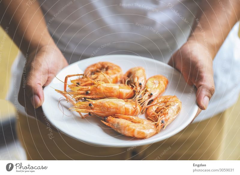 hand holding shrimp grilled prawns cooked in the seafood Seafood Nutrition Eating Lunch Dinner Plate Ocean Restaurant Fresh Delicious Green Red Black White