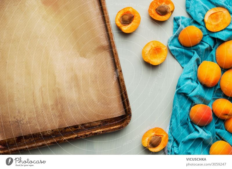 Food background with fresh whole and halved apricot bunch and empty baking sheet, top view. Seasonal fruits concept. food background seasonal nutrition tasty