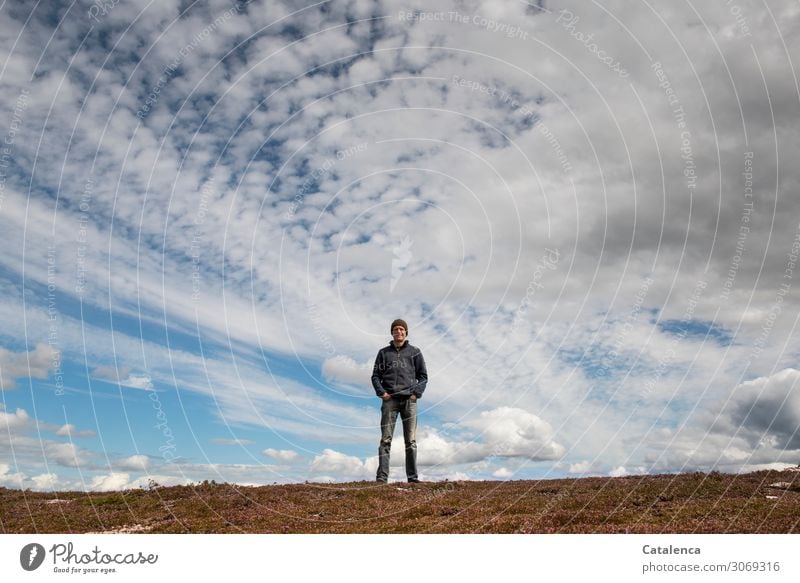 Man standing on the hilltop, the wide sky decorated with clouds above him Nature Landscape person masculine Stand Observe red cap Horizon Sky Clouds Weather
