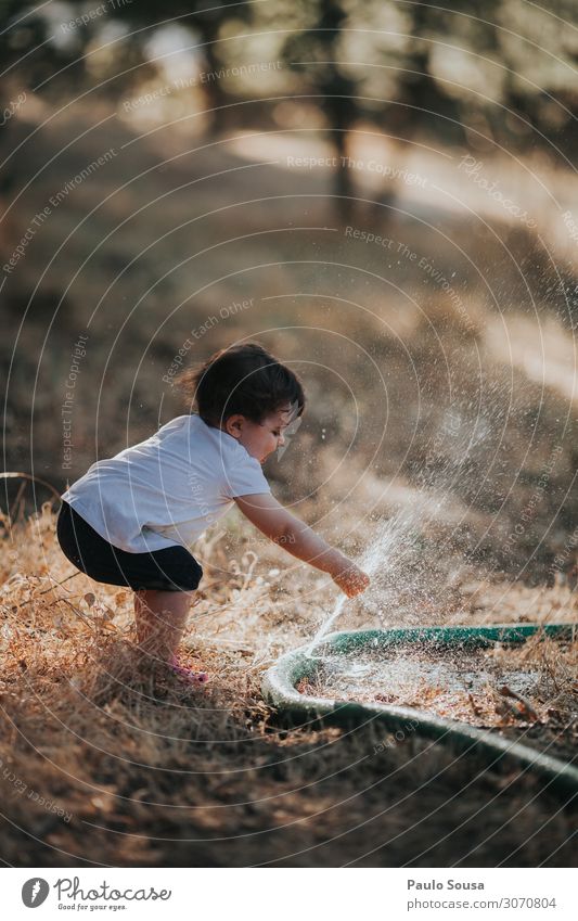Child playing with water hose Lifestyle Human being Toddler Girl 1 1 - 3 years Summer Touch To enjoy Playing Happiness Happy Funny Curiosity Wild Self-confident