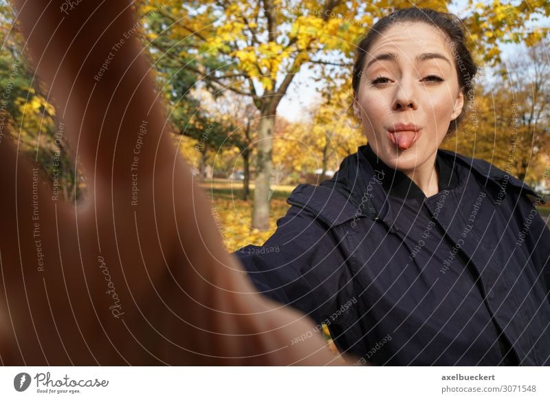 young woman sticks out her tongue with a camera - no photos stick out one's tongue Brash Take a photo Funny Selfie by hand Lifestyle Joy Leisure and hobbies