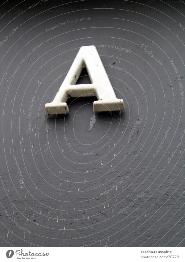 A of course... Letters (alphabet) House number Wall (building) Gray White Things Shadow Dirty