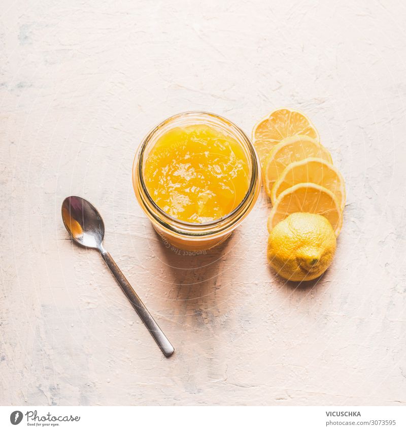 Lemon curd in glass with sliced lemon and spoon on white table, top view lemon curd organic background creamy fruit custard ingredient pudding delicious dessert