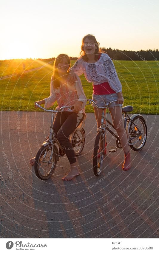 Two girls on bicycles, in nature at sunset. Vacation & Travel Trip Adventure Far-off places Freedom Joy luck Happiness Contentment Joie de vivre (Vitality)