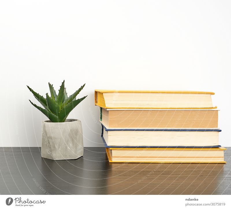 stack books on a black table and a ceramic pot Pot Reading Table Science & Research School Study Classroom Academic studies Workplace Business Book Library