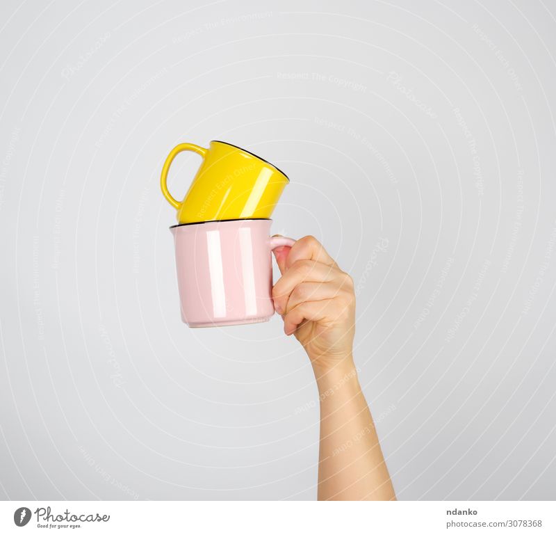 female hand holding a stack of ceramic mugs Breakfast To have a coffee Beverage Coffee Espresso Tea Design Kitchen Woman Adults Arm Hand Fingers Hot Yellow Pink