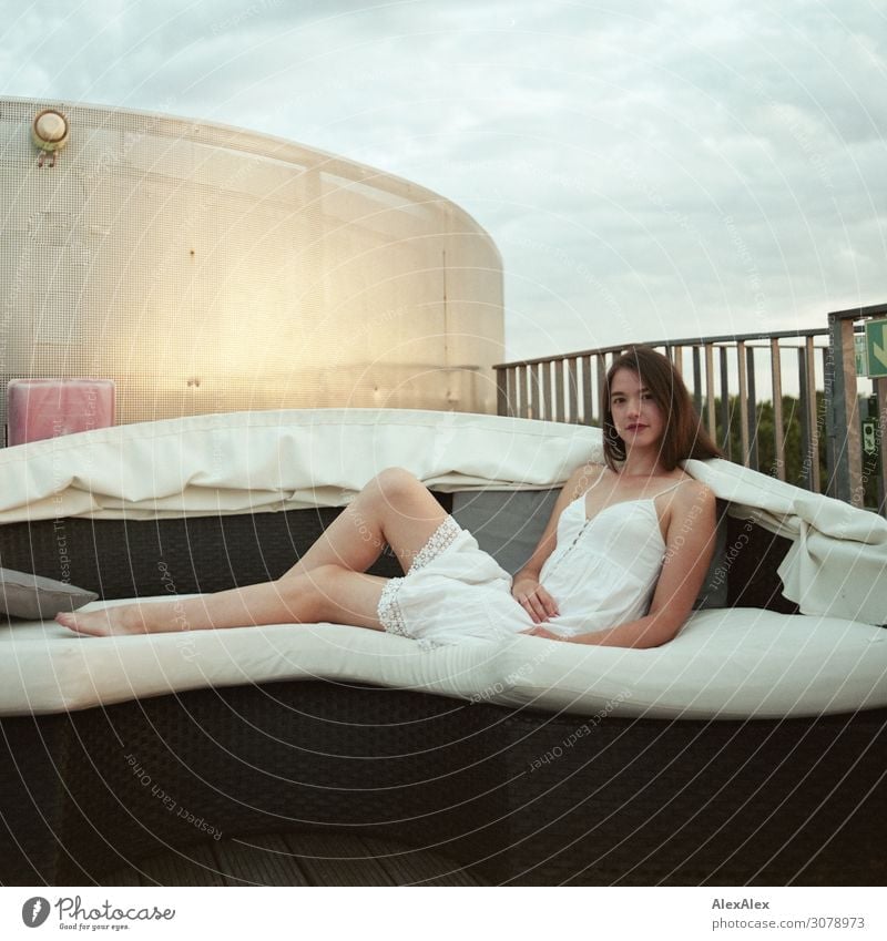 Portrait of a young woman on a sofa of a roof terrace Style Beautiful Wellness Harmonious Sofa Roof Roof terrace Young woman Youth (Young adults) Legs Barefoot