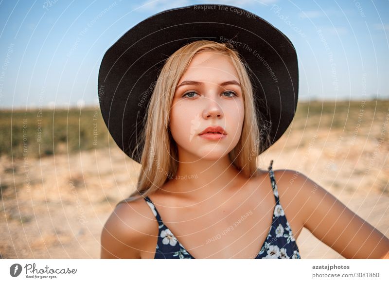 a close-up portrait of a blue-eyed blonde girl in a black hat Black Blonde Blue calm Close-up Dress during Expressive eyes Face Woman Floral glamour Gorgeous
