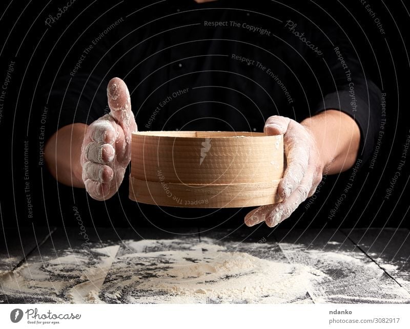man sifts white wheat flour through a wooden sieve Dough Baked goods Bread Nutrition Table Kitchen Human being Man Adults Hand Sieve Wood Movement Make Fresh