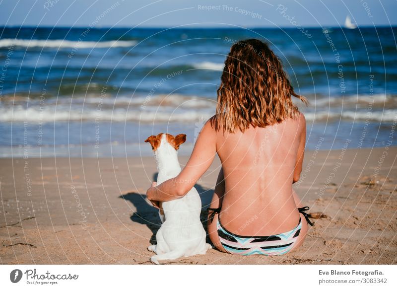 young woman and her cute small jack russell terrier sitting at the beach enjoying and relaxing. Summer and holidays concept Youth (Young adults) Relaxation Blue