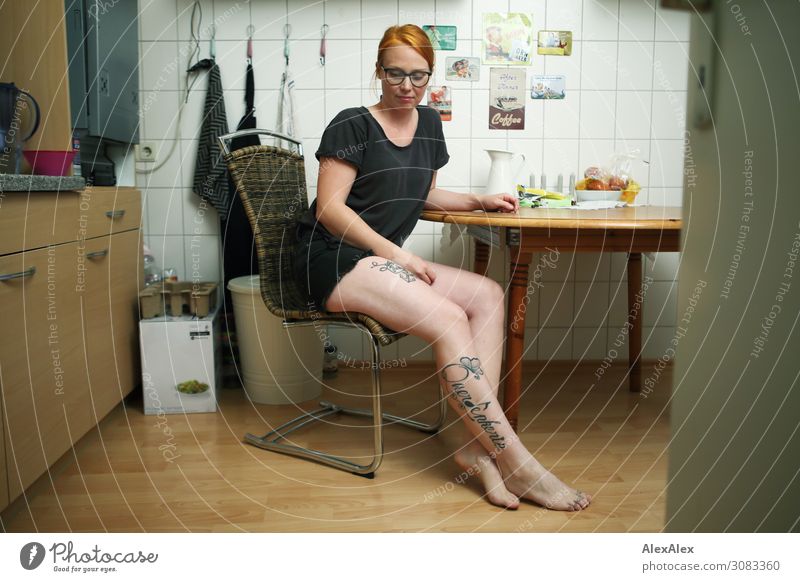 Portrait of a young, tattooed woman sitting barefoot in her kitchen Food Style already Harmonious Flat (apartment) cake Young woman Youth (Young adults) Legs