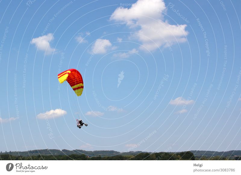 Toy paraglider with hanging vehicle and figure flying in front of a blue sky with clouds Leisure and hobbies Environment Nature Sky Clouds Summer