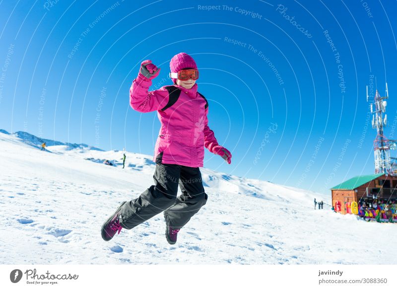 Little girl jumping on the snow at Sierra Nevada ski resort. Joy Happy Relaxation Leisure and hobbies Playing Vacation & Travel Winter Snow Mountain Sports