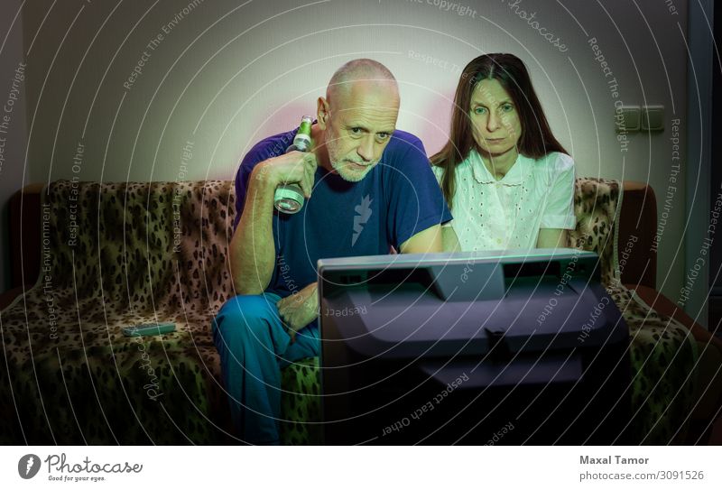 Middle-aged man and woman, watch television, looking sad Drinking Alcoholic drinks Beer Lifestyle Face Relaxation Leisure and hobbies Sofa Entertainment