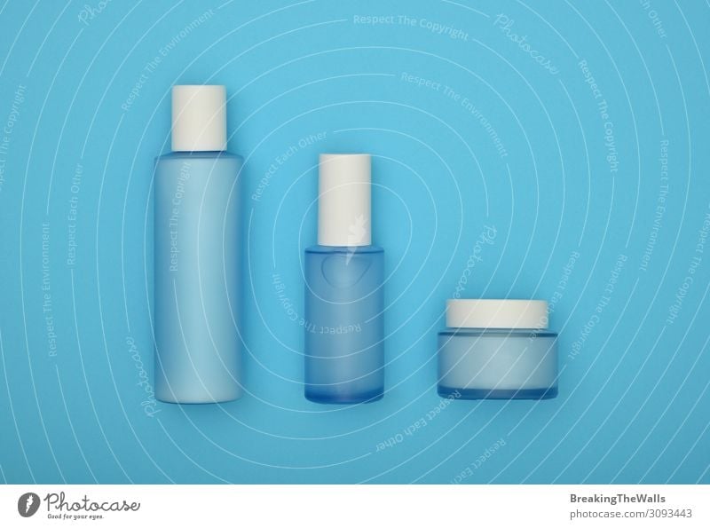 Different, colorful beauty toiletries, cream jars, soaps and towels on the  blue background. Body relax and care products for women and men. Empty  place for text or a logo. Front view. Stock