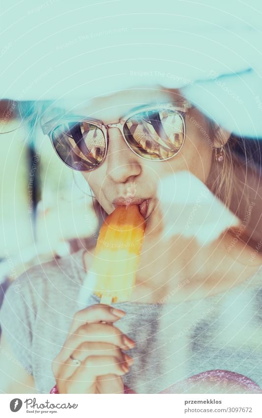 Young woman eating a ice cream, sitting in a chair outdoors on a patio during summer day Ice cream Eating Lifestyle Relaxation Vacation & Travel Summer
