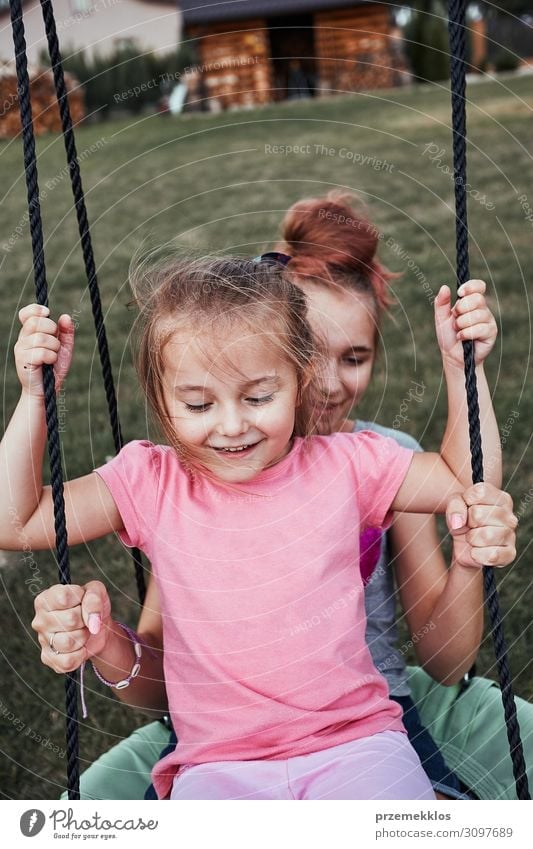 Sisters having fun on a swing together Joy Happy Summer Summer vacation Garden Child Family & Relations 2 Human being 3 - 8 years Infancy 13 - 18 years