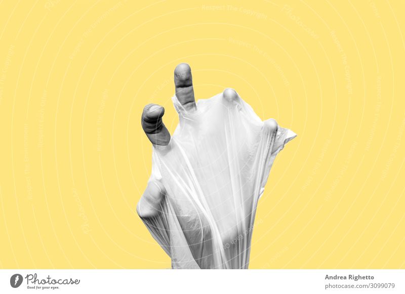 Concept of stop plastic pollution, global warming, recycling plastic, plastic free, zero plastic. Hand wrapped in a plastic bag. Yellow background with a black and white subject