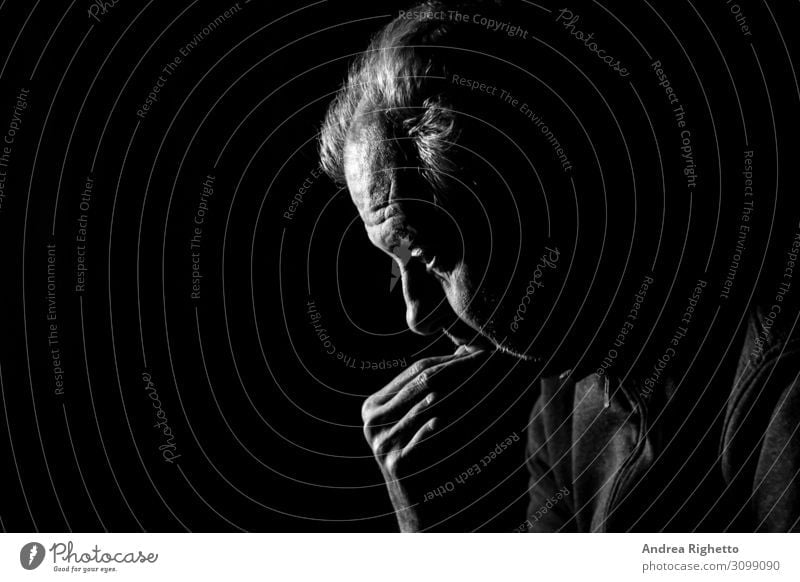 Concept of depression. Old man staring at nothing in the dark in black and white with a black background Health care Medical treatment Care of the elderly