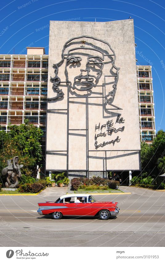 Portrait of Che Guevara on a house wall in Cuba with a vintage car in the foreground Vintage car che guevara portrait Havana Street Facade Wall (building)