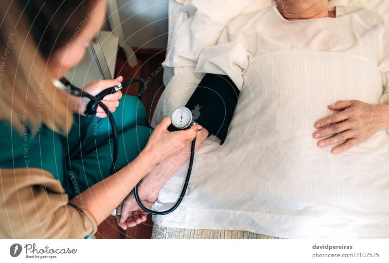 Caregiver checking blood pressure to a senior woman Health care Illness Medication House (Residential Structure) Examinations and Tests Doctor Hospital