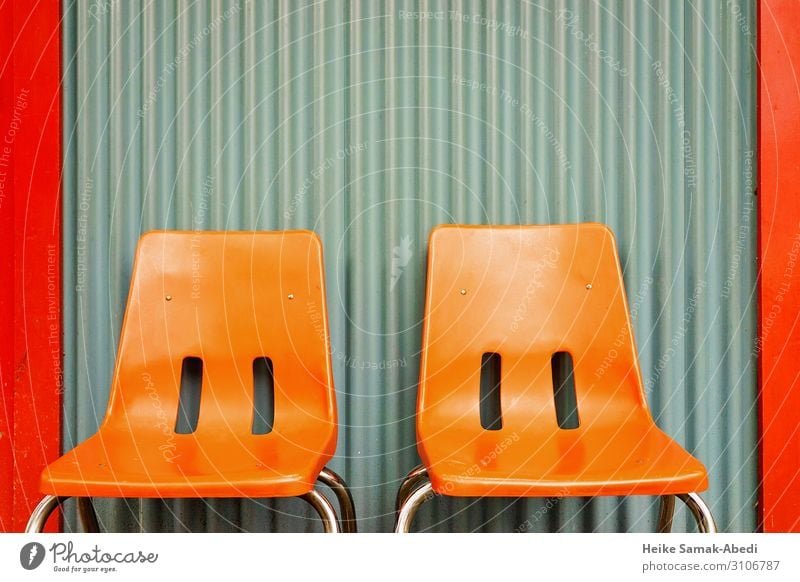 Orange-coloured chairs in front of a corrugated sheet metal wall Interior design Furniture Chair Wall (barrier) Wall (building) Facade Sit Break Calm Relaxation