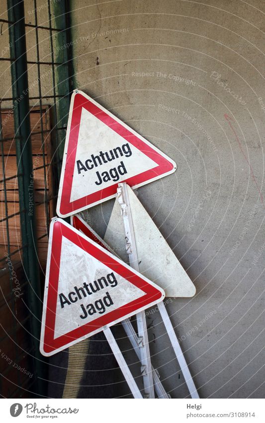 several warning signs with the inscription "Achtung Jagd" are placed on a wall Wall (barrier) Wall (building) Metal Characters Signage Warning sign Stand