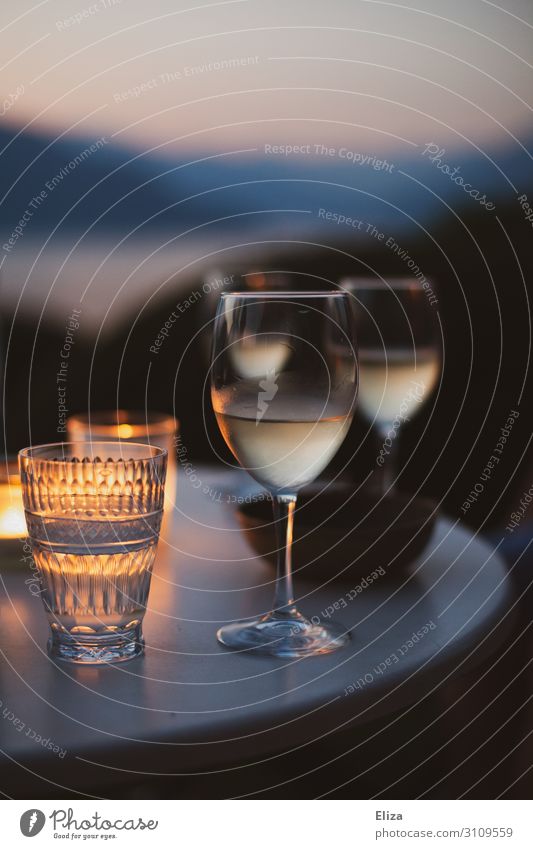 A table with two wine glasses outside in summer in a cosy evening atmosphere with candles Beverage Alcoholic drinks Vine Relaxation Vacation & Travel White wine