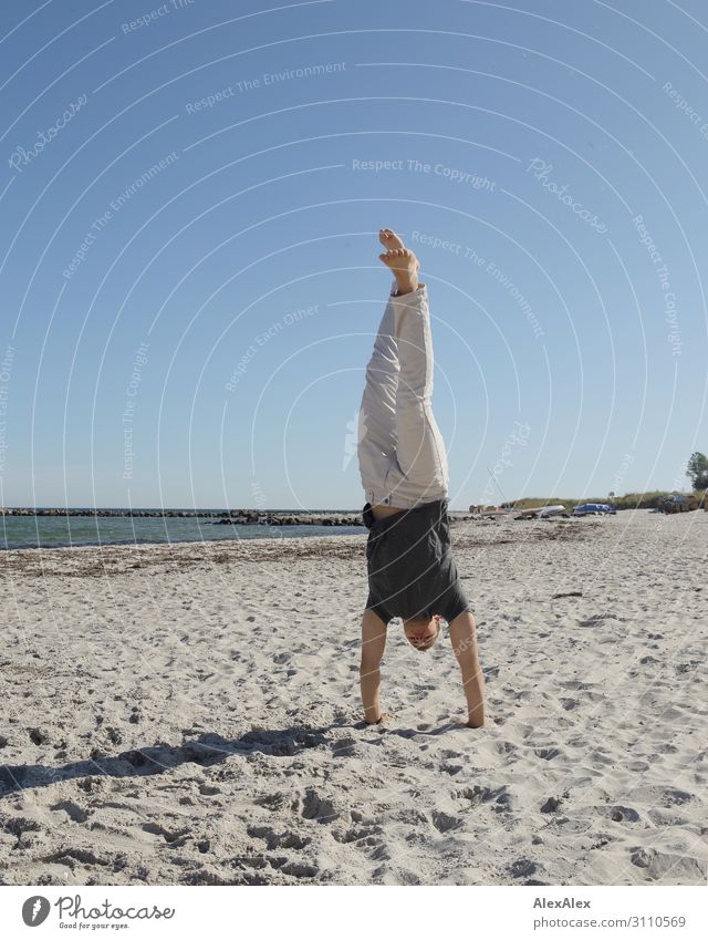 Young, sporty man does handstand on the beach of the Baltic Sea Lifestyle Joy Athletic Fitness Summer Summer vacation Beach Ocean Track and Field Handstand