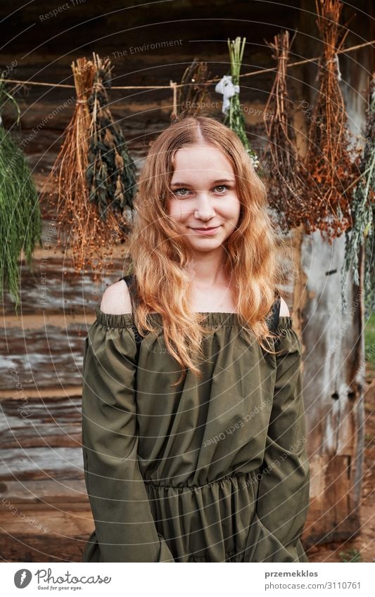 Portrait of young woman standing in front of old cottage Herbs and spices Happy Medical treatment Alternative medicine Medication Camera Girl Young woman