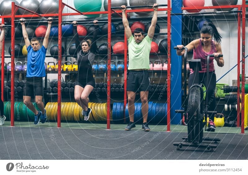 Athletes doing pull ups and air bike in the gym Lifestyle Sports Ball Human being Woman Adults Man Group Fitness Authentic cross-training workout of the day fit