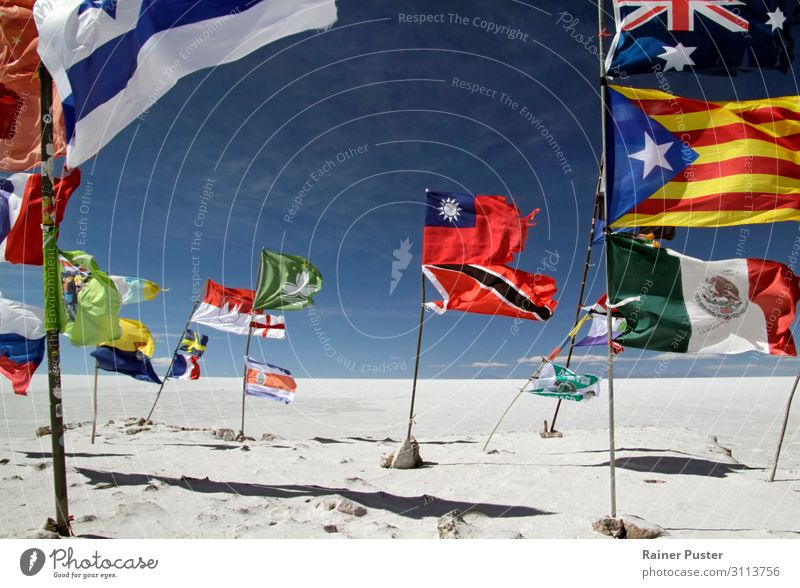 Different flags are waving colourful against the background of the Salar de Uyuni salt desert in Bolivia. Sand Cloudless sky Beautiful weather Wind Desert