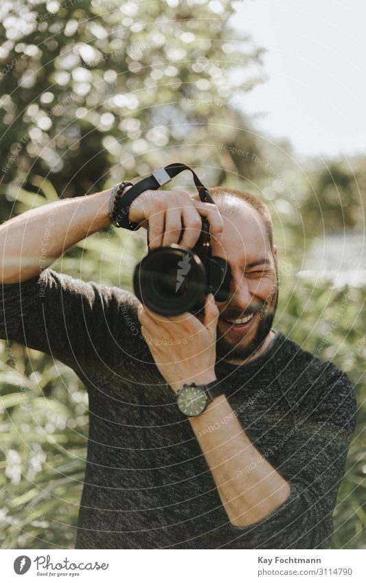 Happy photographer is taking a photo beard camera caucasian digital equipment fun green happy lifestyle man nature nature photography outdoors people person
