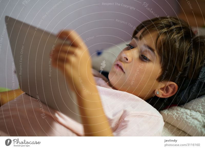 Cute girl using a tablet computer in her bedroom Lifestyle Joy Happy Beautiful Face Leisure and hobbies Playing Bedroom Child School Computer Technology