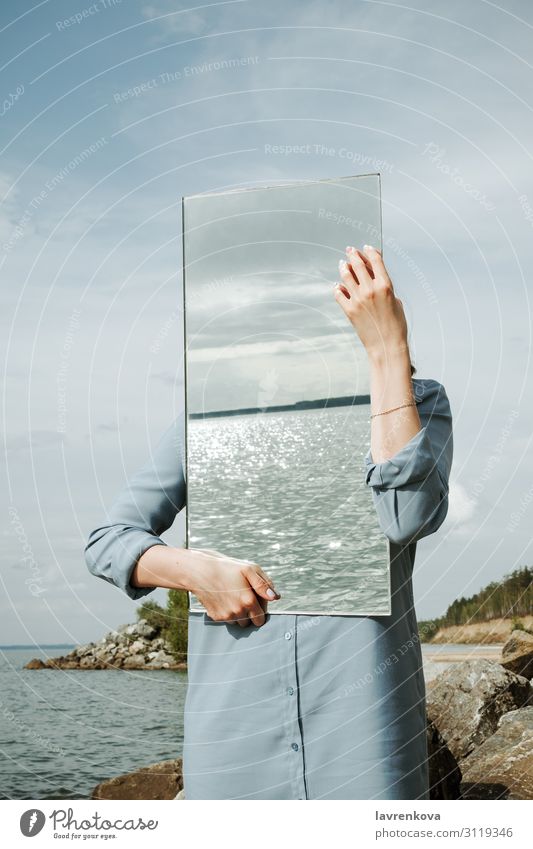 woman standind on a shore in blue dress holding a mirror Adults Clean Conceptual design Dress Environment Faceless Hand Vertical Mirror Nature Exterior shot