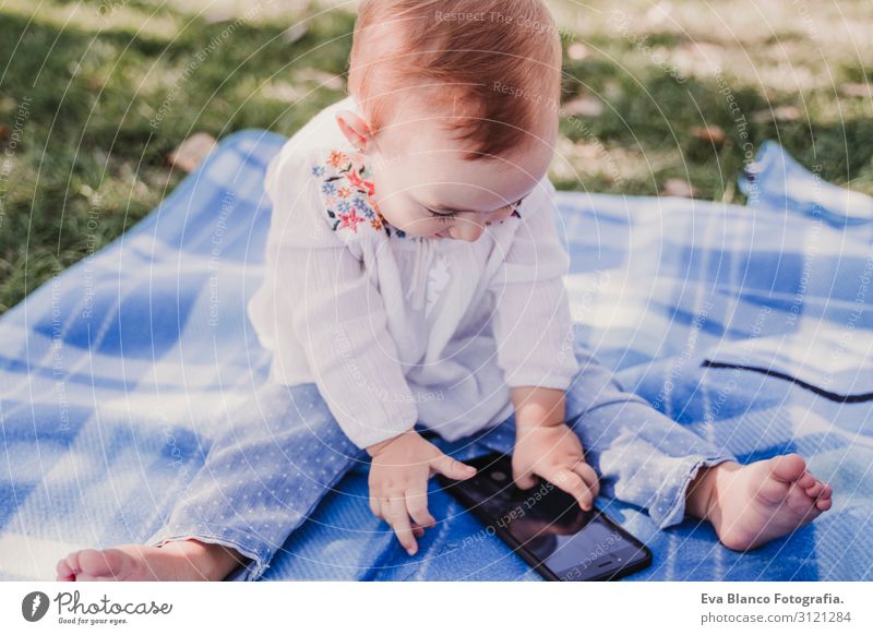 baby girl outdoors in a park using mobile phone Lifestyle Joy Happy Beautiful Playing Summer Sun Parenting Child Cellphone PDA Screen Technology Internet