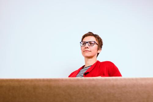 Woman sitting, next to a white wall, in front of a cardboard box Room Services Business Meeting To talk Adults 1 Human being 30 - 45 years Observe Looking Sit